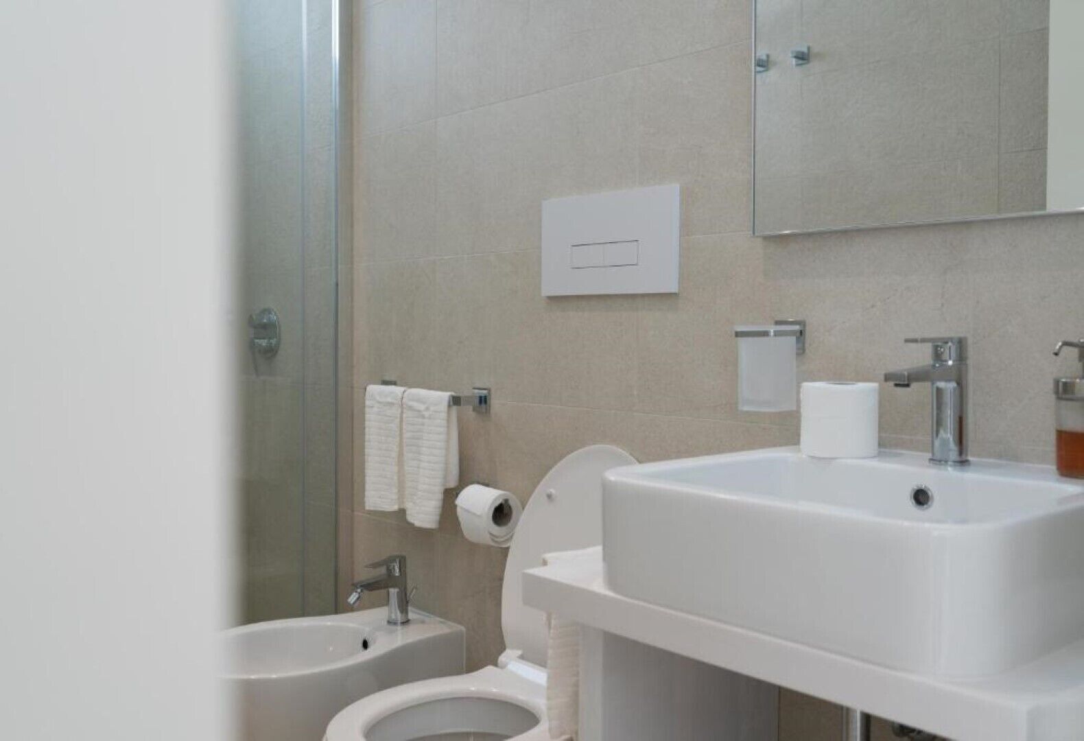 Une salle de bain moderne équipée d’une douche, de toilettes et d’un lavabo.