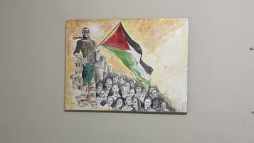Una pintura que muestra una figura sosteniendo una bandera, con una multitud abajo.