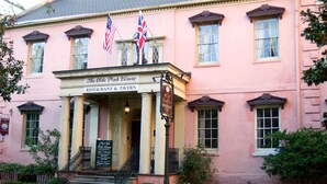 The Olde Pink House, en rosa byggnad med en klassisk fasad, där det finns en skylt som visar att det är en restaurang och ett värdshus.
