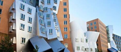 Ein modernes Gebäude mit markanter, eckiger Architektur und zahlreichen Fenstern.