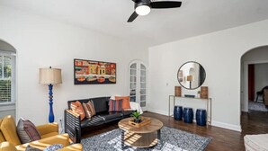 A modern living room with a black sofa, a round coffee table, and a blue floor lamp. - Colorful, waterside home (Bradenton)