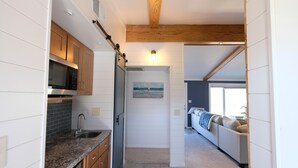 Una cocina moderna con gabinetes de madera, encimera de granito y microondas integrado.