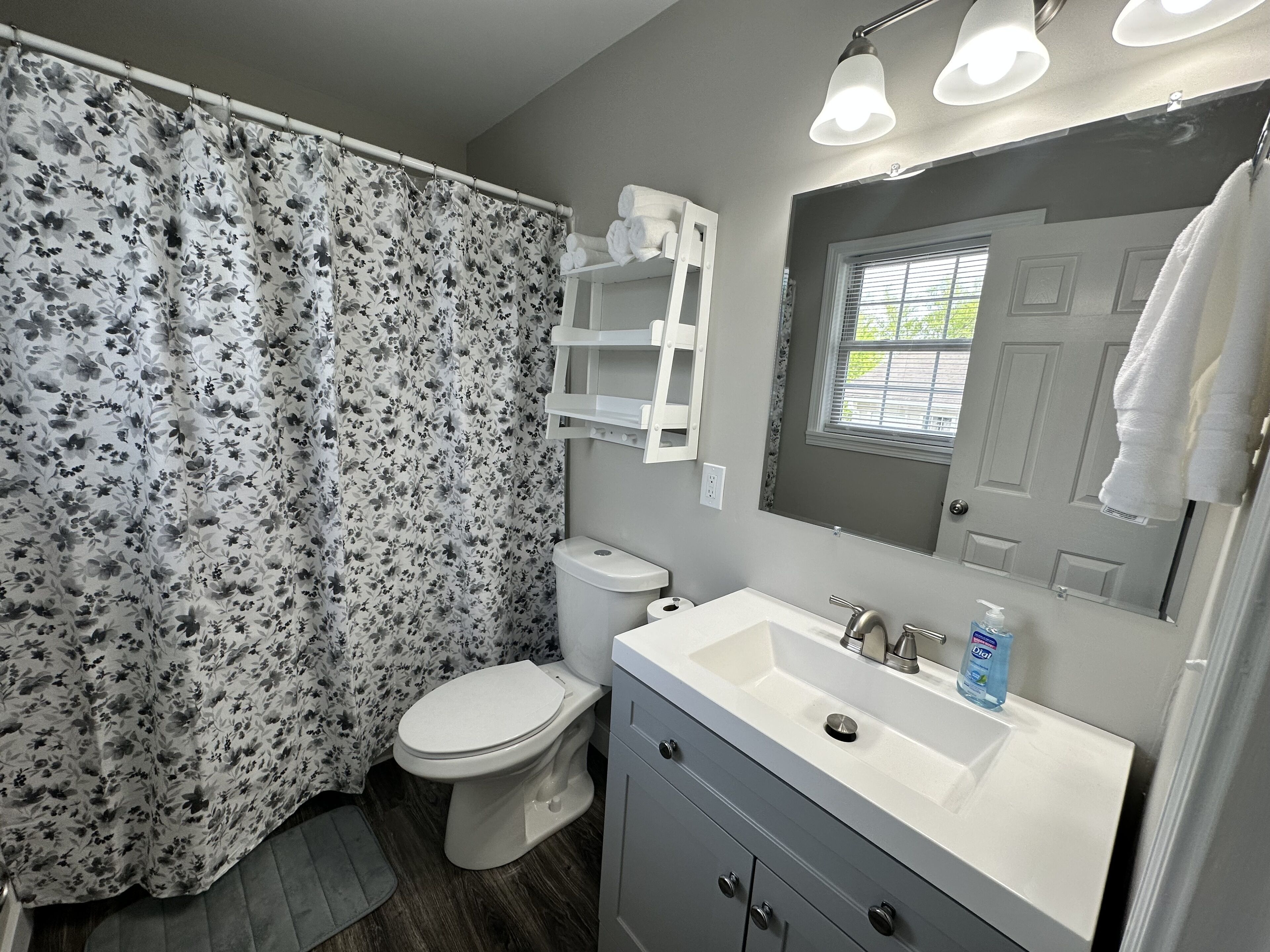 A bathroom with a toilet, sink, and shower curtain.