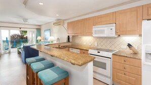 A modern kitchen with wooden cabinets, a granite countertop, and a built-in oven.