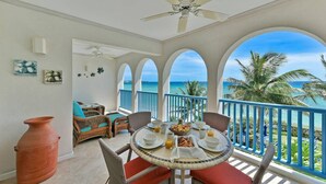 A balcony with a table set for breakfast, overlooking the ocean. - #302 Oceanview beachfront Maxwell Beach Villas (Christ Church)