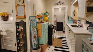 A kitchen with a black and white striped rug, a blue refrigerator, and a white sink. - Adorable & Romantic French Corner by Downtown, The Heights & WOMH - Pet Friendly (Houston)