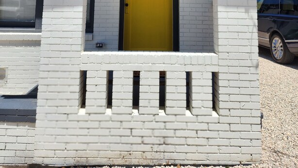 A building with a yellow door, a number 905 sign above it, and a small porch area. - Adorable & Romantic French Corner by Downtown, The Heights & WOMH - Pet Friendly (Houston)