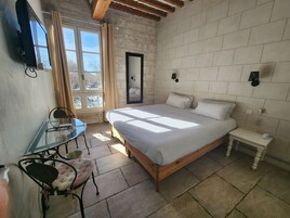 A bedroom with a bed, bedside table, and a small table with chairs.