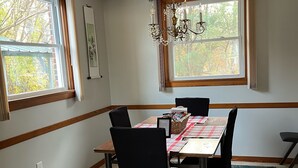 A dining room with a wooden table, black chairs, a patterned rug, and a chandelier. - Lynchburg Family Living - close to Liberty University and dining options (Lynchburg)