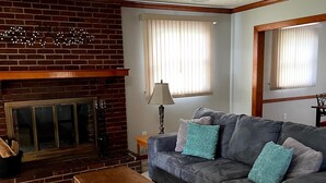 A living room with a fireplace, a sofa, a coffee table, and a ceiling fan. - Lynchburg Family Living - close to Liberty University and dining options (Lynchburg)