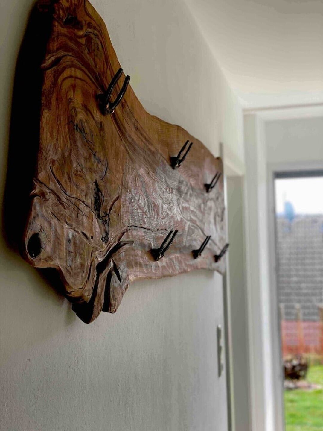 Un porte-manteau mural en bois, doté de crochets.
