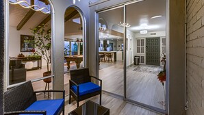 A modern interior with a glass door leading to a dining area and kitchen.