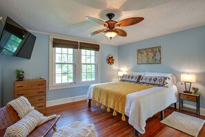 A bedroom with a bed, a ceiling fan, a window with blinds, a dresser, a chair, and a painting on the wall. - Luxury Oasis near FSU w/King bed (Tallahassee)