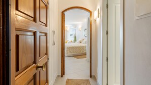 A hallway leading to a bedroom with a bed, a bedside table, and a lamp. - WELCS ESTUDIO 057 EMP Frente al Mar (Empuriabrava)