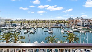 A marina with numerous boats docked, surrounded by buildings and palm trees. - WELCS APARTAMENTO 216 EMP Frente con Terraza (Empuriabrava)
