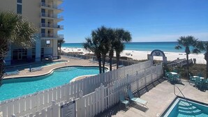 A hotel pool area with a view of the beach, a white fence, and a sign with the number 39. - Pool in Backyard and steps to beach (Panama City)