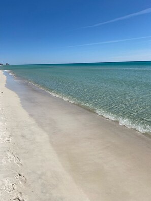 Una playa con aguas transparentes y una orilla arenosa.