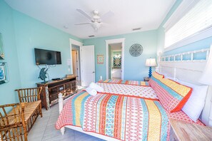 Une chambre à coucher avec un lit, un bureau, une chaise et un téléviseur.