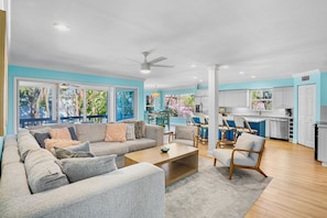 Relax in this open-plan living space with a large sofa, coffee table, and armchairs.