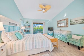 A bedroom with a bed, a ceiling fan, a dresser, a chair, and a TV.