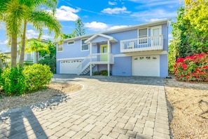 A two-story house with a front porch, a staircase leading to a balcony, and a garage.