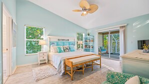 A bedroom with a bed, a bench, a bookshelf, and a sliding glass door to a balcony. - Canal Front Home with Dock, Saltwater Pool, Ping Pong - Ama Maria (Anna Maria)