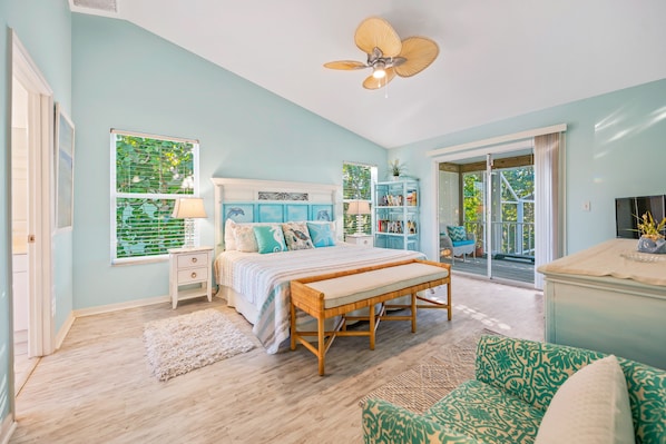 A bedroom with a bed, a bench, a bookshelf, and a sliding glass door to a balcony.