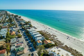 Stunning coastal homes line the beachfront, offering breathtaking ocean views.