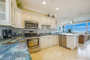 Enjoy cooking in this kitchen with a sink, stainless steel appliances, and a large window offering a view of the outdoors.