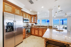 Enjoy cooking in this kitchen with a large island, sink, and ocean views through large windows.