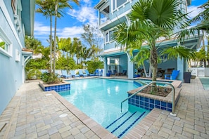 Relax by the pool surrounded by lush greenery and comfortable lounge seating.