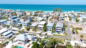 A coastal residential area with houses, a road, and a beach. - Bayblue — Spacious 6BR Retreat with Pool and Dock! (Bradenton Beach)