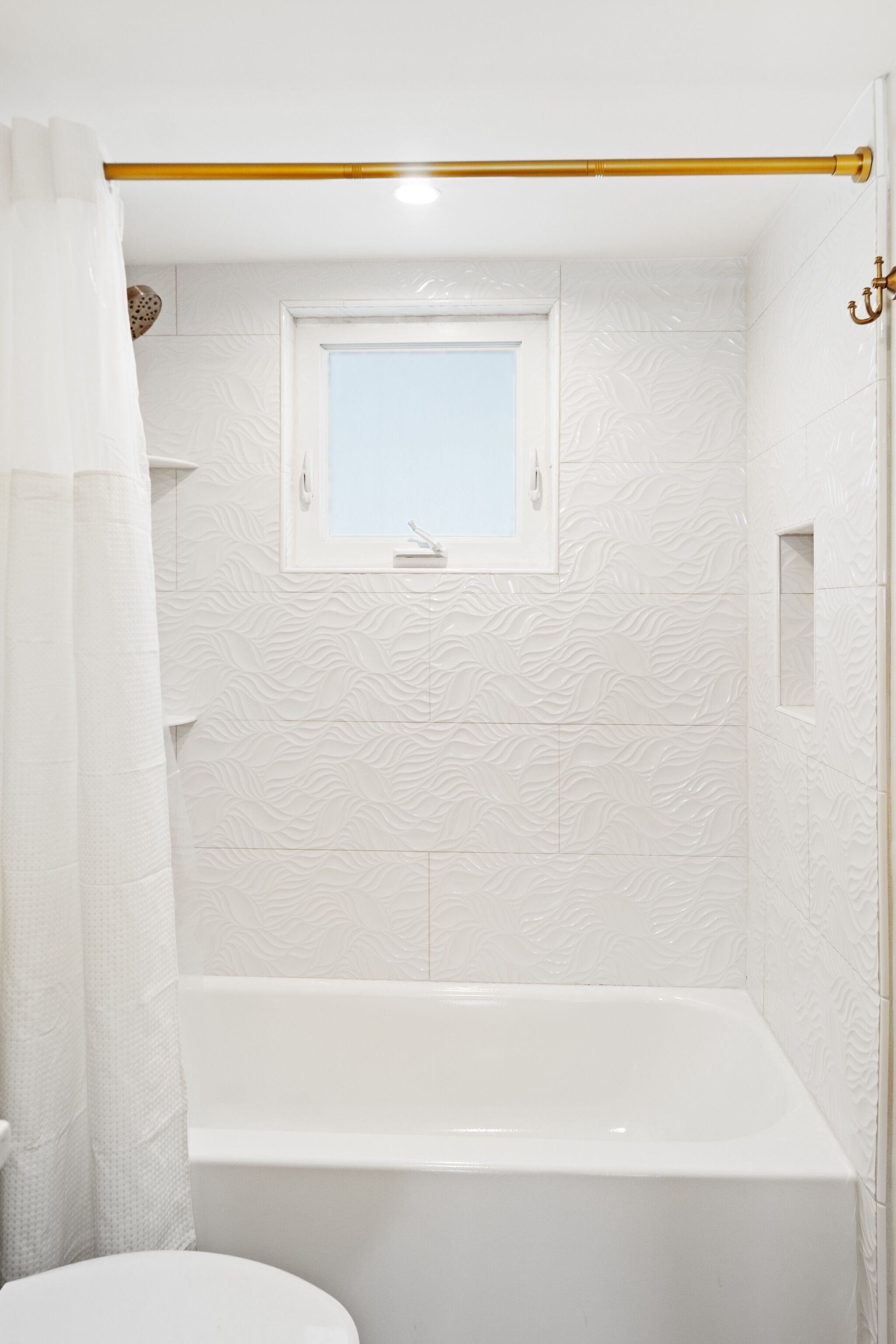 Un bagno con vasca, finestra e tenda da doccia.