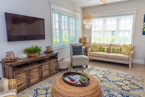 Relax in style with a comfortable sofa, large flat-screen TV, and natural textures.