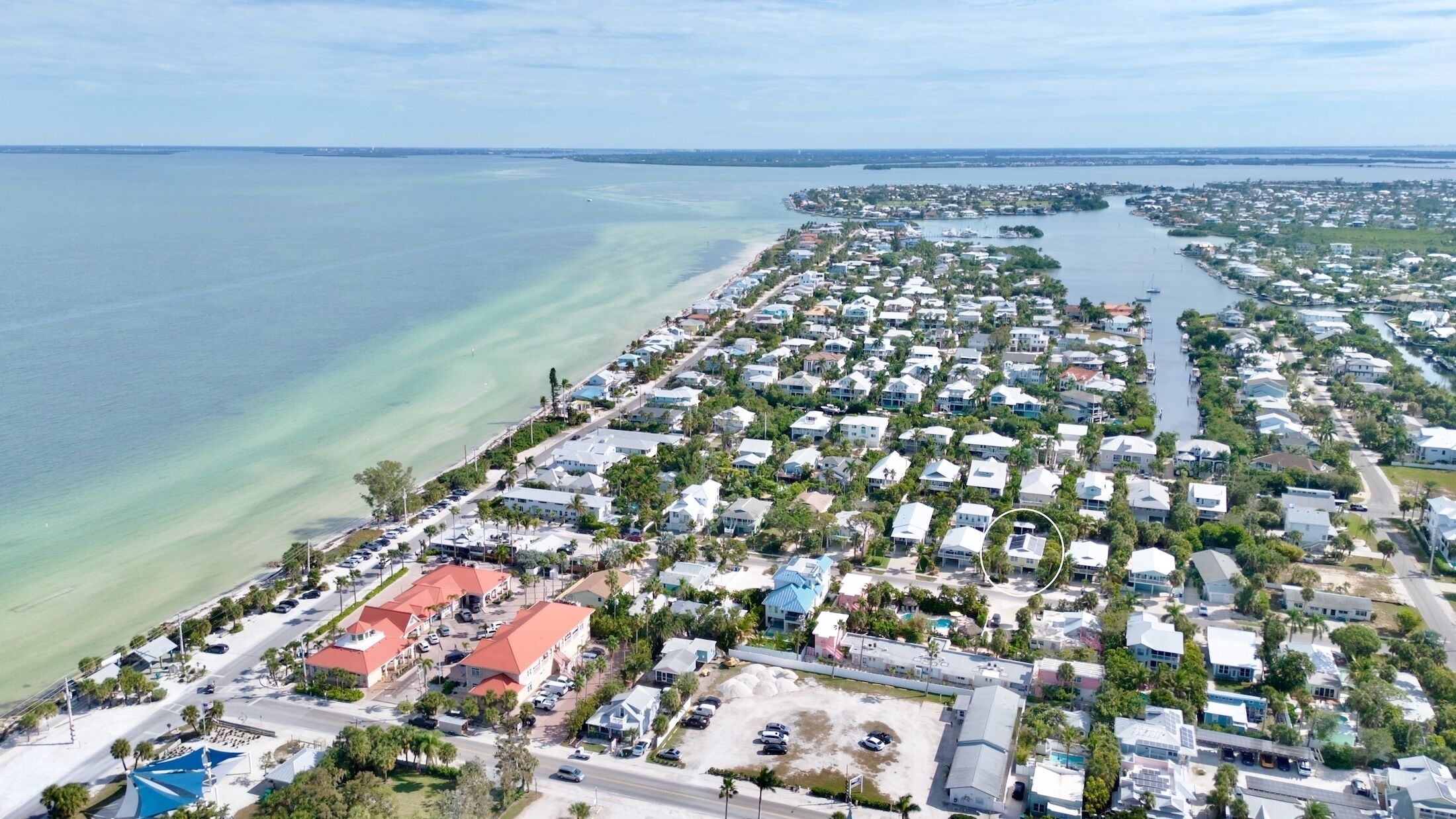 Une zone résidentielle côtière comprenant des maisons, une plage et un port de plaisance.