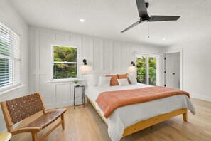 Relax in a serene bedroom with a large bed, wooden headboard, and ceiling fan.