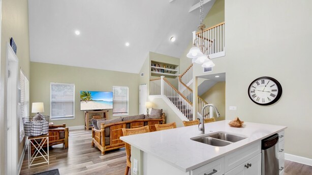A modern kitchen with white cabinetry, a stainless steel sink, and a built-in dishwasher. - Large Private Beach Home! Heated Pool, Elevator, Balcony, and Near the Beach! (Holmes Beach)