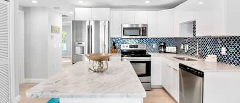 Enjoy a fully equipped kitchen with a sleek cabinetry, refrigerator, microwave, oven, and dishwasher.