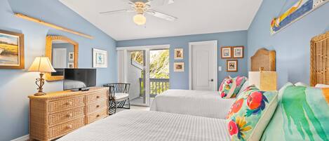 A bedroom with two beds, a TV, a dresser, and a ceiling fan.