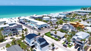 A coastal resort area with multiple buildings, a swimming pool, and a beach. - Beach Home with Pool and Gas Grill! 2 min walk to Beach! (Holmes Beach)
