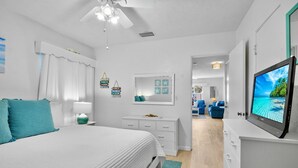 Un dormitorio moderno con una cama, una mesita de noche y un televisor.