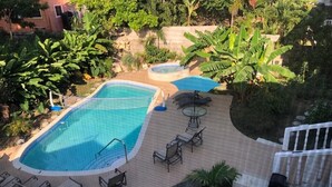 Et poolområde med flere pools, liggestole og et lille bord.
