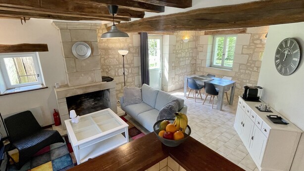 Una sala acogedora con chimenea, una mesa de comedor y una zona de cocina.