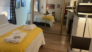 Une chambre d’hôtel avec un lit, un miroir, un bureau et une télévision.