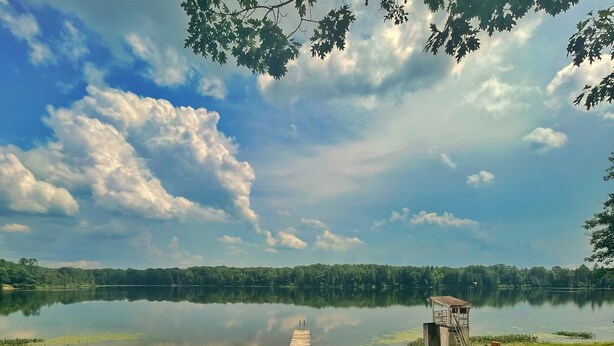A wooden boardwalk leading to a lake with a sandy beach and a small structure on the right. - Arrowhead Lake Camp - Black Bear Lodge Lake View (Lupton)