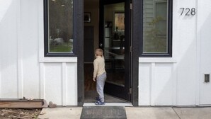A modern building entrance with a large glass door, a welcome mat, and the number 728 on the wall. - Greenough Loft (Missoula)