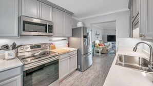 A modern kitchen with stainless steel appliances, a built-in oven, and a large refrigerator.
