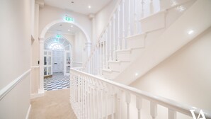 Un magnifique escalier avec des rampes blanches menant à l’étage supérieur.