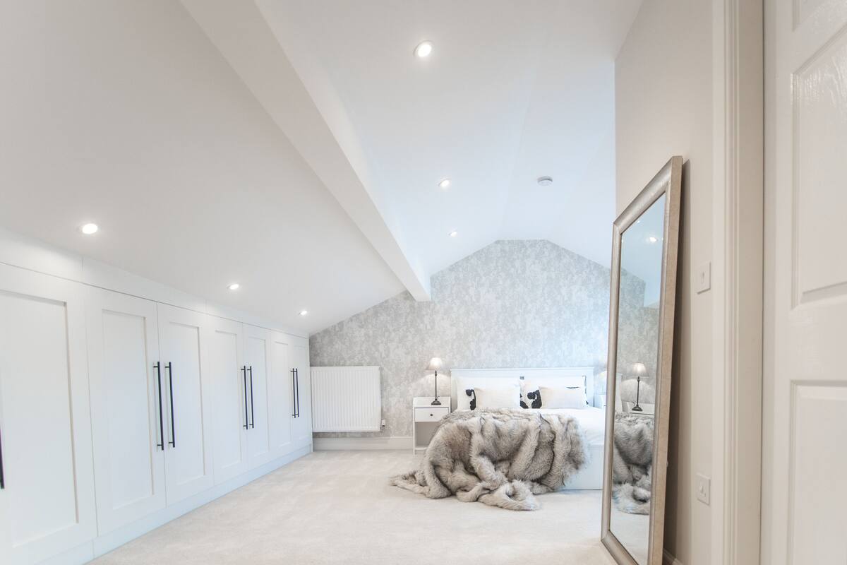 Une chambre spacieuse et bien éclairée, dotée d’un grand miroir, d’un tapis moelleux et d’un lit confortable.