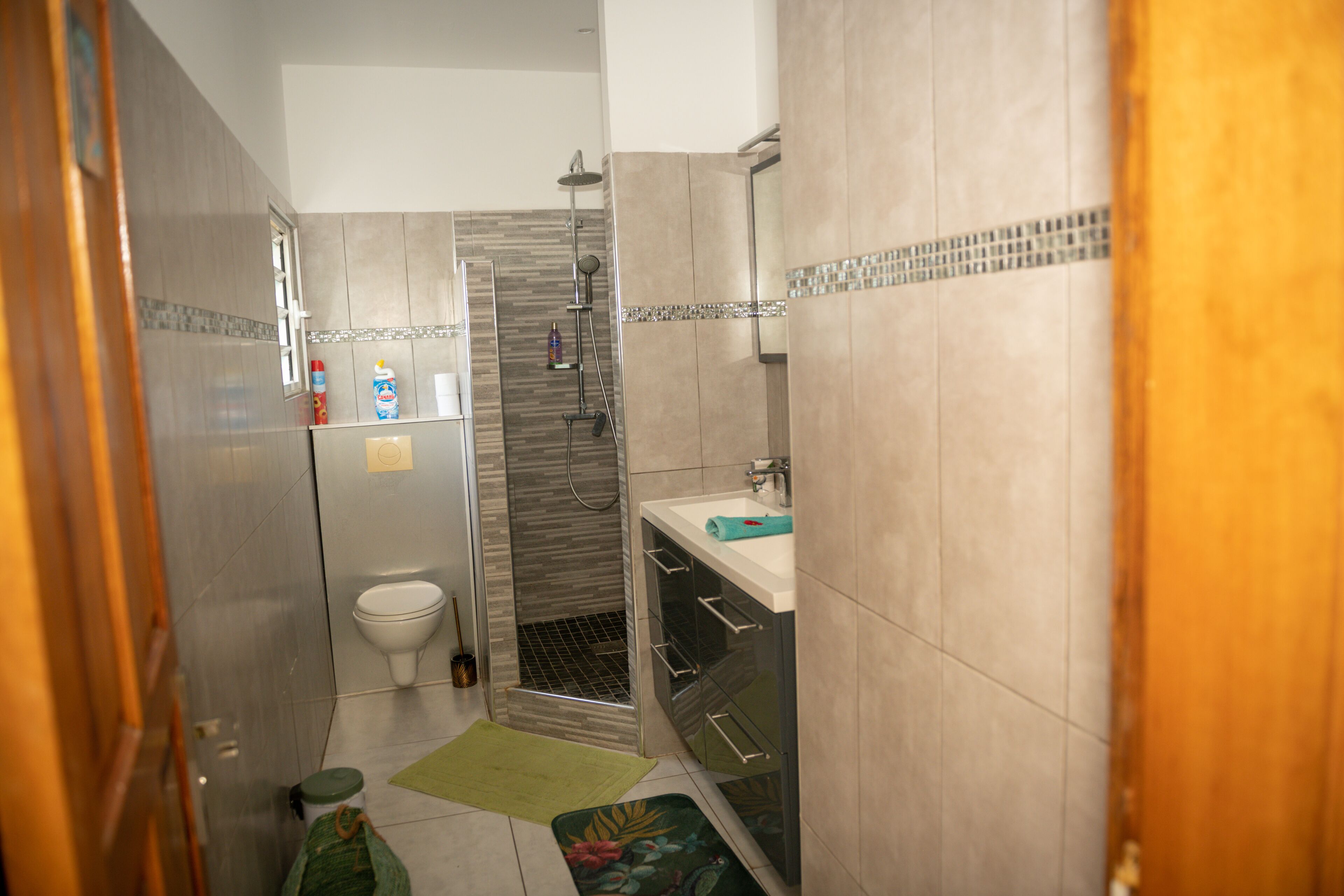 A compact bathroom with a toilet, shower, and sink.